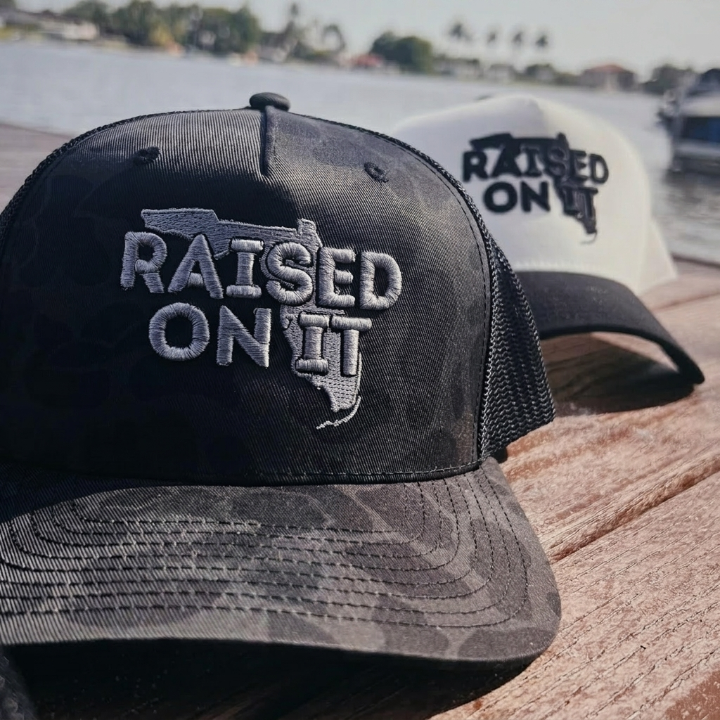 Silver Camo Florida Logo trucker hat on a dock with the White/Black colorway behind